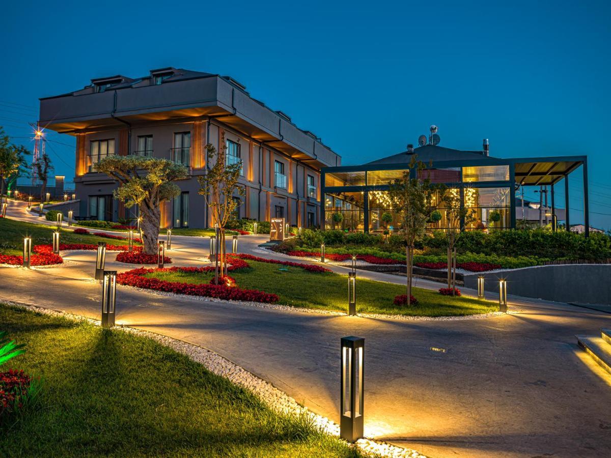 Menalo Hotel Premium Istanbul Airport Екстериор снимка The photo shows a beautifully designed modern building set in a landscaped area during twilight. There are illuminated pathways leading up to the structure, which features stylish architecture with large windows. Surrounding the building are well-mai